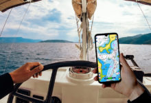 man using a phone while sea navigation