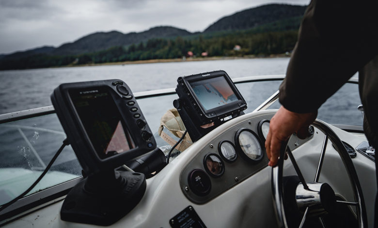 A man on his boat deck steering the wheel with a digital map