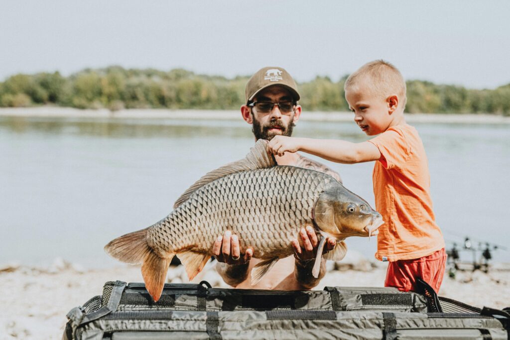 man and son with a fish kill bag